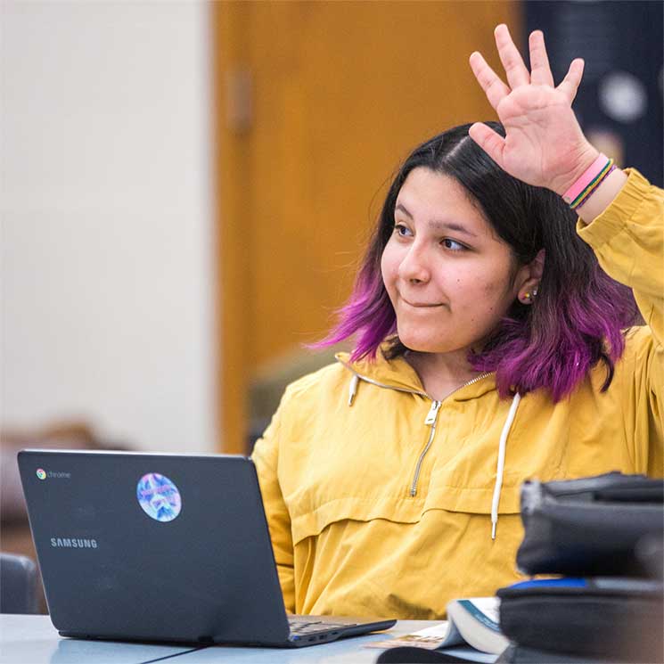 middle school student raised hand Middle school student engaged in learning
