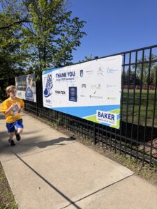 runner on the Baker 5K course in front of banner